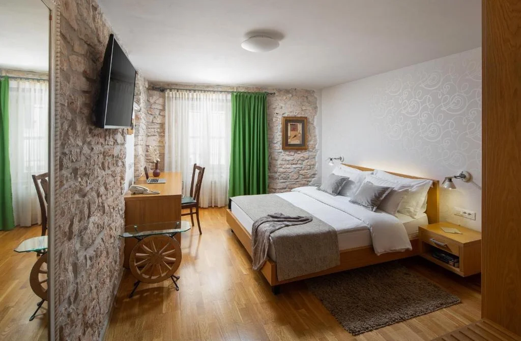 Hotel La Grisa Bale Doppelzimmer Superior Bett Tisch Stuhl Gruen